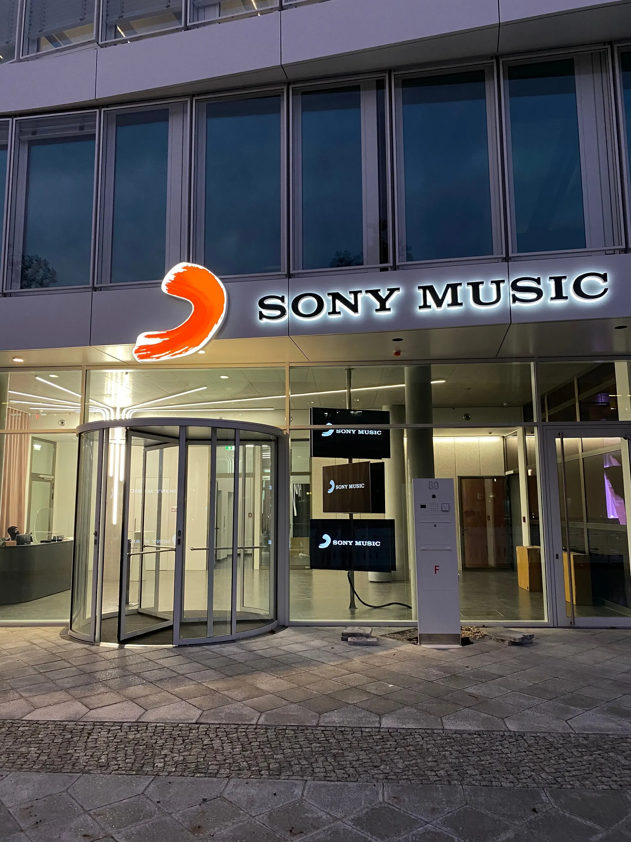 Eingang von Sony Music mit Drehtür und beleuchtetem Schriftzug